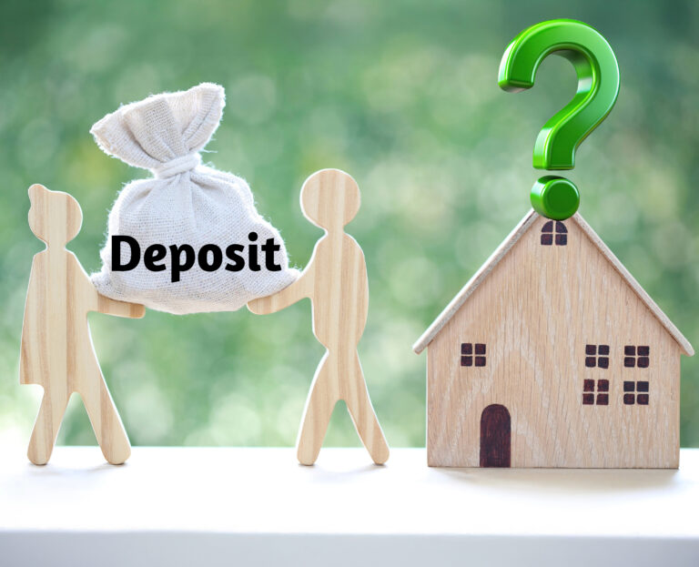 a house next to two wooden figures holding a bag that says deposit