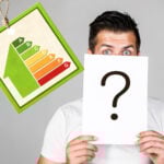 A person holding a question mark and an EPC graph hanging next to them