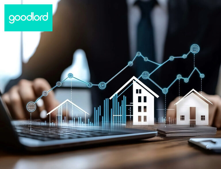 A person sitting at a desk with a digital image of homes and a graph increasing