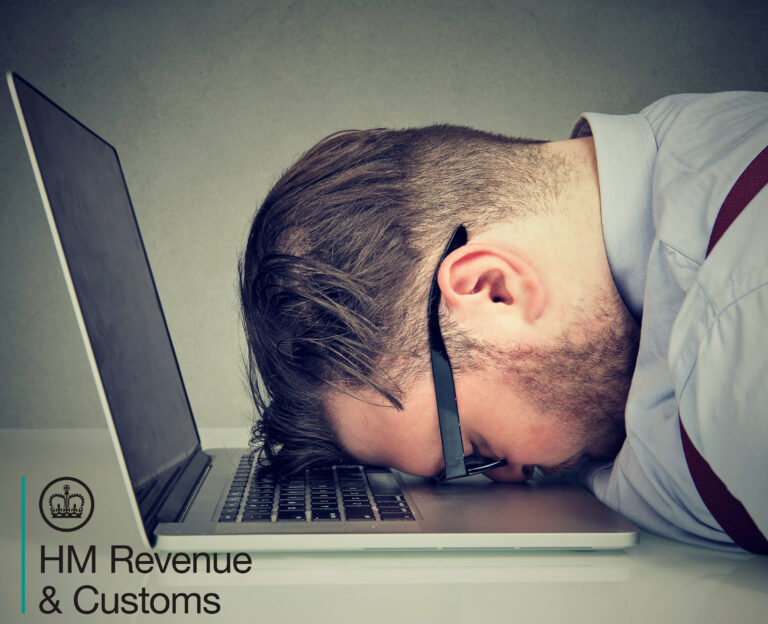 Frustrated man with head on laptop over HMRC digital tax requirements