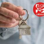 A person holding a keyring of a house