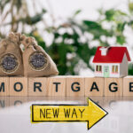 Wooden blocks spelling out Mortgage. money bags, a home, New way sign, and plants in the background
