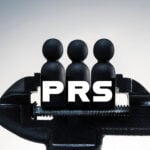 A clamp holding figures of people with the word PRS