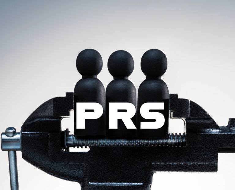 A clamp holding figures of people with the word PRS