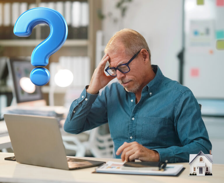 A man sitting at a desk holding his head, a laptop and bookcase and a Question mark