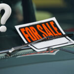 A fore sale sign and a question mark on a cars windscreen