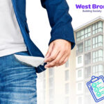 A person showing an empty pocket with a building in the background