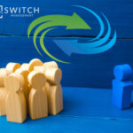 Wooden figures in a circle with a blue wooden figure outside of the circle, swirling arrows in a circle and a blue background