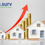 a row of three houses with stacks of coins and an upwards arrow