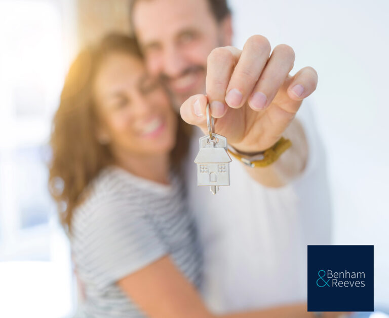 A couple hugging holding house keys