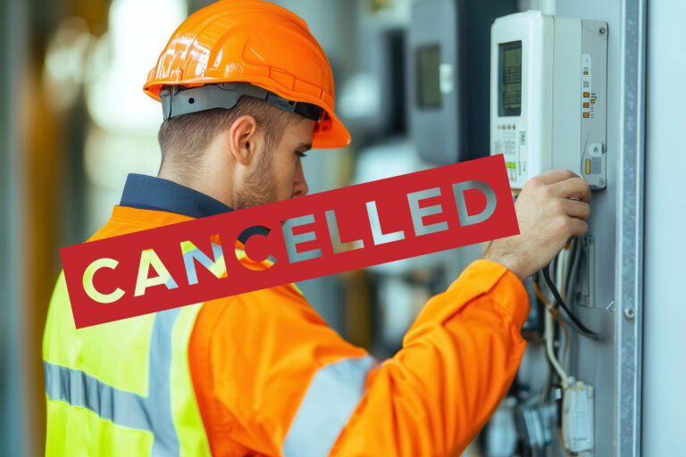 A person with a safety vest on with a safety orange helmet working on a smart meter and the word cancelled