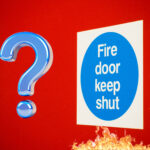 Fire door keep shut sign and question mark sign with a red background
