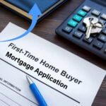 Keys on a keyboard, a first time home buyer mortgage application, and an arrow pointing upwards