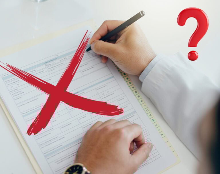 A person writing on a form with a Red cross and question mark