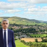 Sadiq Khan with houses and countryside in the back ground
