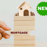 Wooden house on sliding blocks and text Mortgage and New