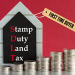 Red background, stacks of coins from small to large, Stamp Duty Land Tax and, First time buyer text