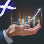 Hand holding coins with an arrow pointing upwards. scottish flag