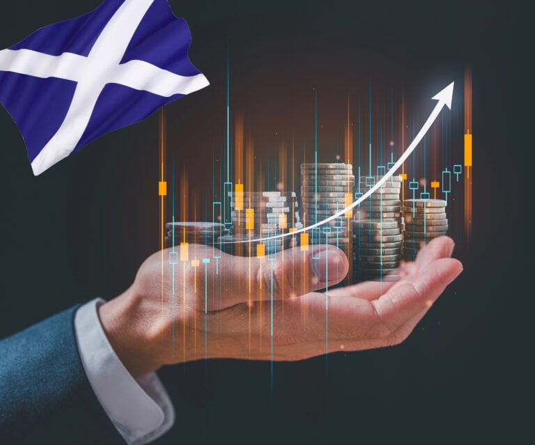 Hand holding coins with an arrow pointing upwards. scottish flag