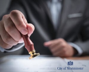 A businessman stamping a form and City of Westminster logo,