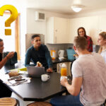 Students sitting round a table with a question mark