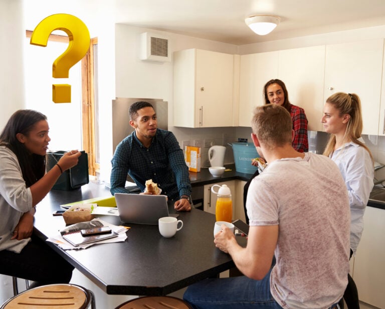 Students sitting round a table with a question mark