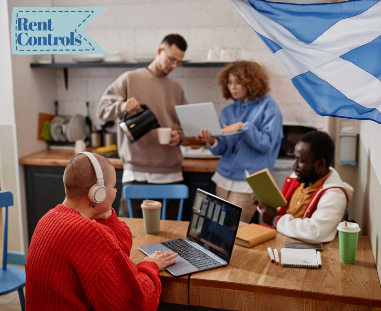 Students around a dining table, a student sitting at the table on a latop wearing headphones and a Scottish flag