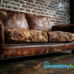 Damaged old brown leather sofa against a wall