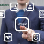 A businessman pressing a button labeled licensing on a digital screen and text saying Hackney