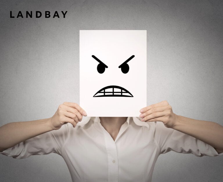 man holding up an angry face over his head