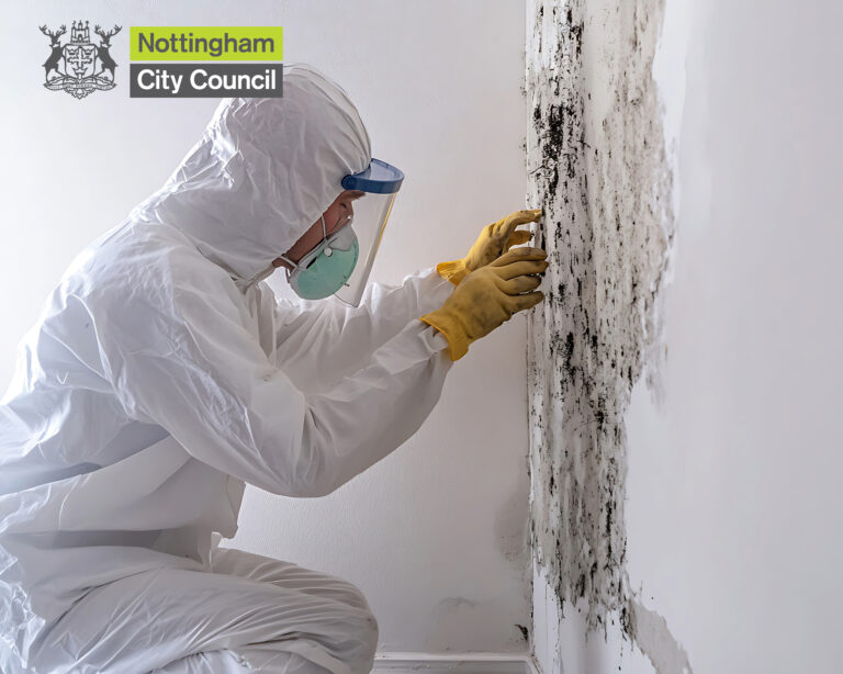 biological suited person with a mask repairing mould inside on a wall with a nottingham sity council logo