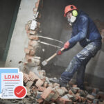 Person knocking down a wall with a sledgehammer and loan paperwork