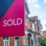 House sold sign with houses in the background