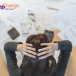 Person stressed over bills and debt paperwork, highlighting financial struggles of private renters