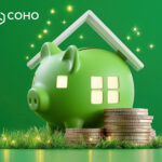 Green piggy bany with house windows and a roof over it with coins