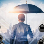 Businessman under umbrella symbolizing landlord protection from financial risks