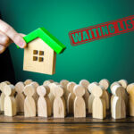 wooden House being held above wooden people with a waiting list stamp