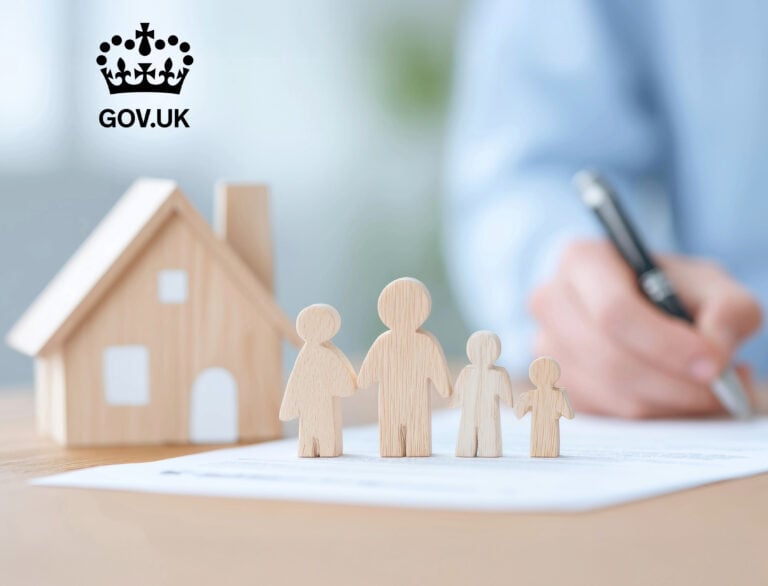Wooden figures of a family beside a house model representing UK government housing plans
