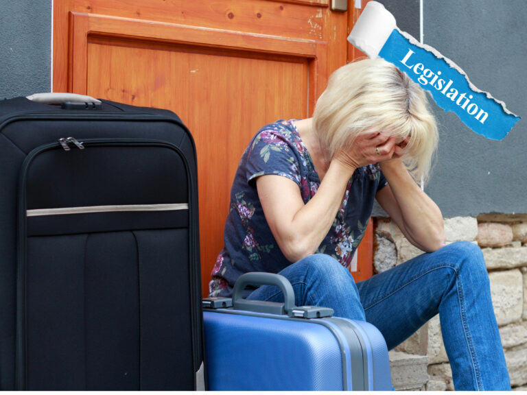 Distressed woman sitting with suitcases outside home, highlighting impact of housing legislation