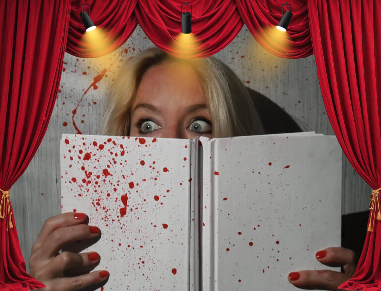 Woman hides behind blood-splattered book under stage lights, symbolizing violent-themed play at Edinburgh Fringe.