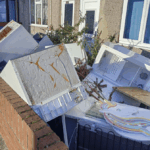 Pile of discarded fridges and waste dumped in front garden of empty house