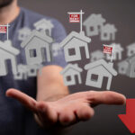 Houses and a down arrow on a mans hand with to rent signs