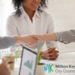 people showing arms shaking hands with another person present acting as a mediator for Milton Keynes city council