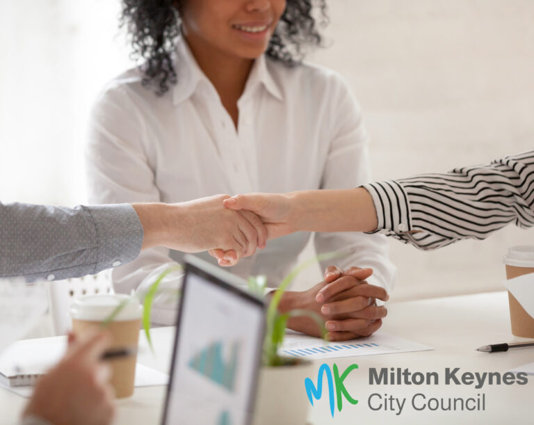 people showing arms shaking hands with another person present acting as a mediator for Milton Keynes city council