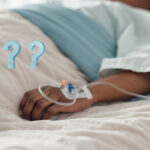 A low view of someone in a hospital bed and question marks