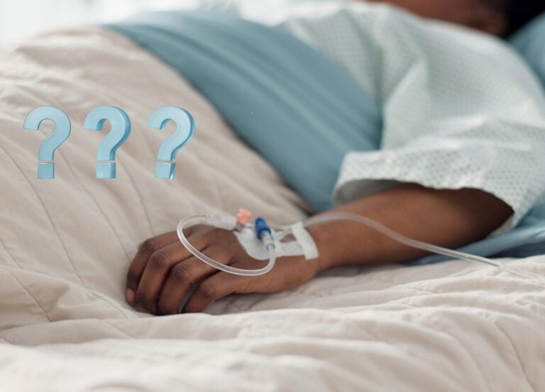 A low view of someone in a hospital bed and question marks