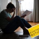 Tenant on floor in despair looking at an eviction notice