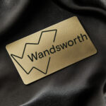 Gold card with wandsworth logo on black silk background