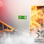 Fire and alarm with stairs in a hallway with the welsh government logo