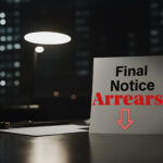 Final notice arrears letter on a desk under lamp light.